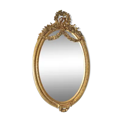Miroir ovale doré avec un noeud et une couronne de fleurs